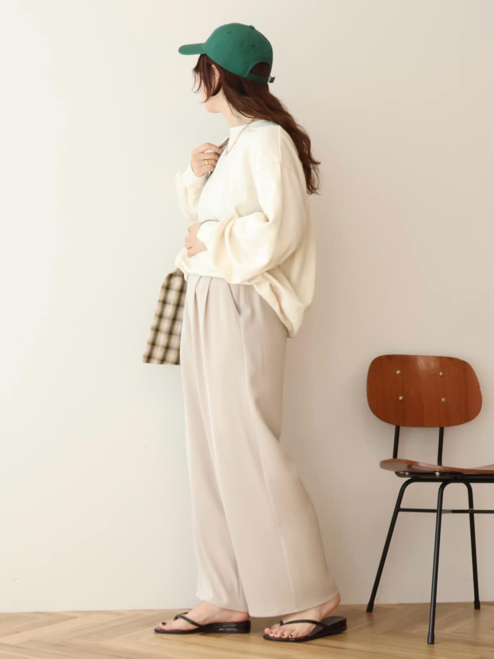 ホワイト系のスウェット、グリーン系のキャップを着用したレディースの春コーディネートの3枚目の写真
