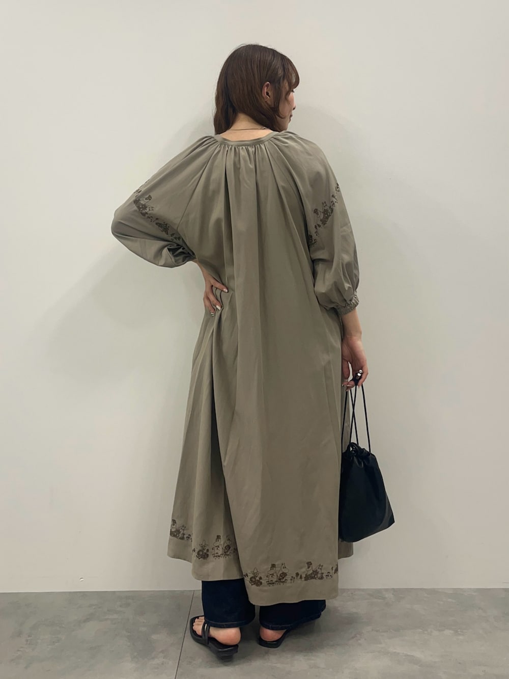 ブルー系のデニムパンツ、ブラック系のショルダーバッグ、ブラック系のサンダルを着用したレディースの春コーディネートの2枚目の写真