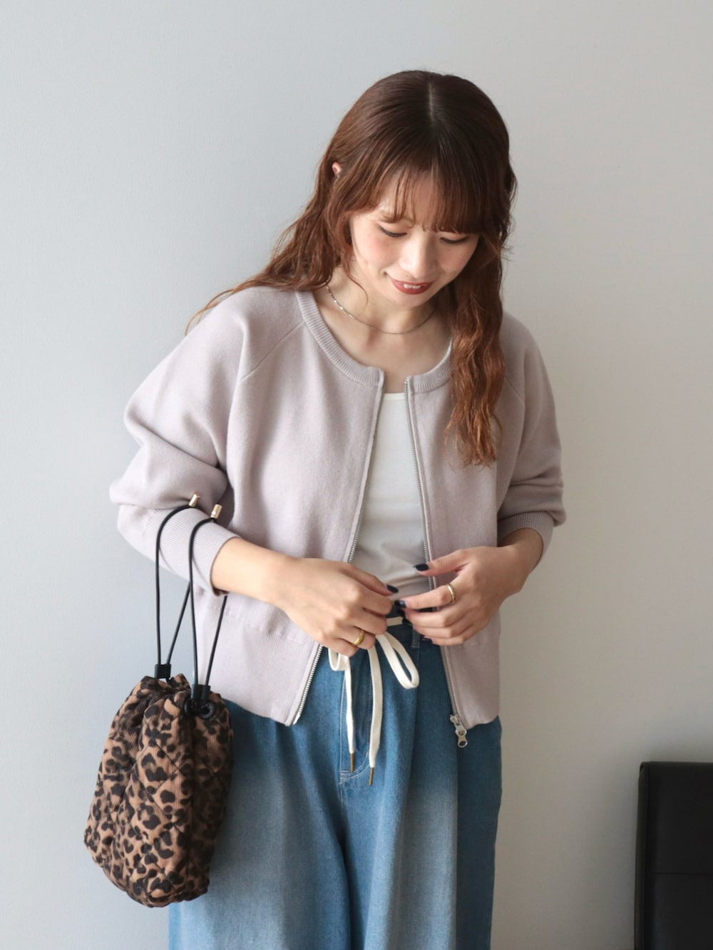 ブルー系のデニムパンツ、ベージュ系のカーディガン/ボレロ、その他のショルダーバッグを着用したレディースの秋コーディネートの3枚目の写真