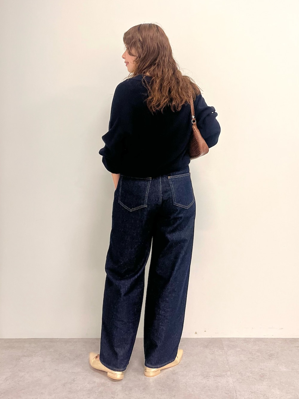 ブルー系のデニムパンツ、ブルー系のニット/セーターを着用したレディースの秋コーディネートの3枚目の写真