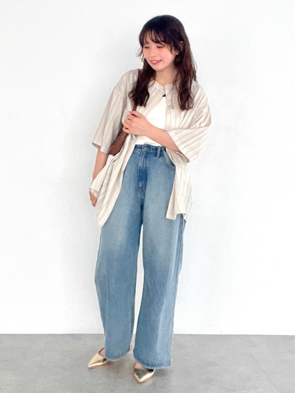 ブルー系のデニムパンツ、ホワイト系のタンクトップ、ホワイト系のシャツ/ブラウスを着用したレディースの夏コーディネートの2枚目の写真