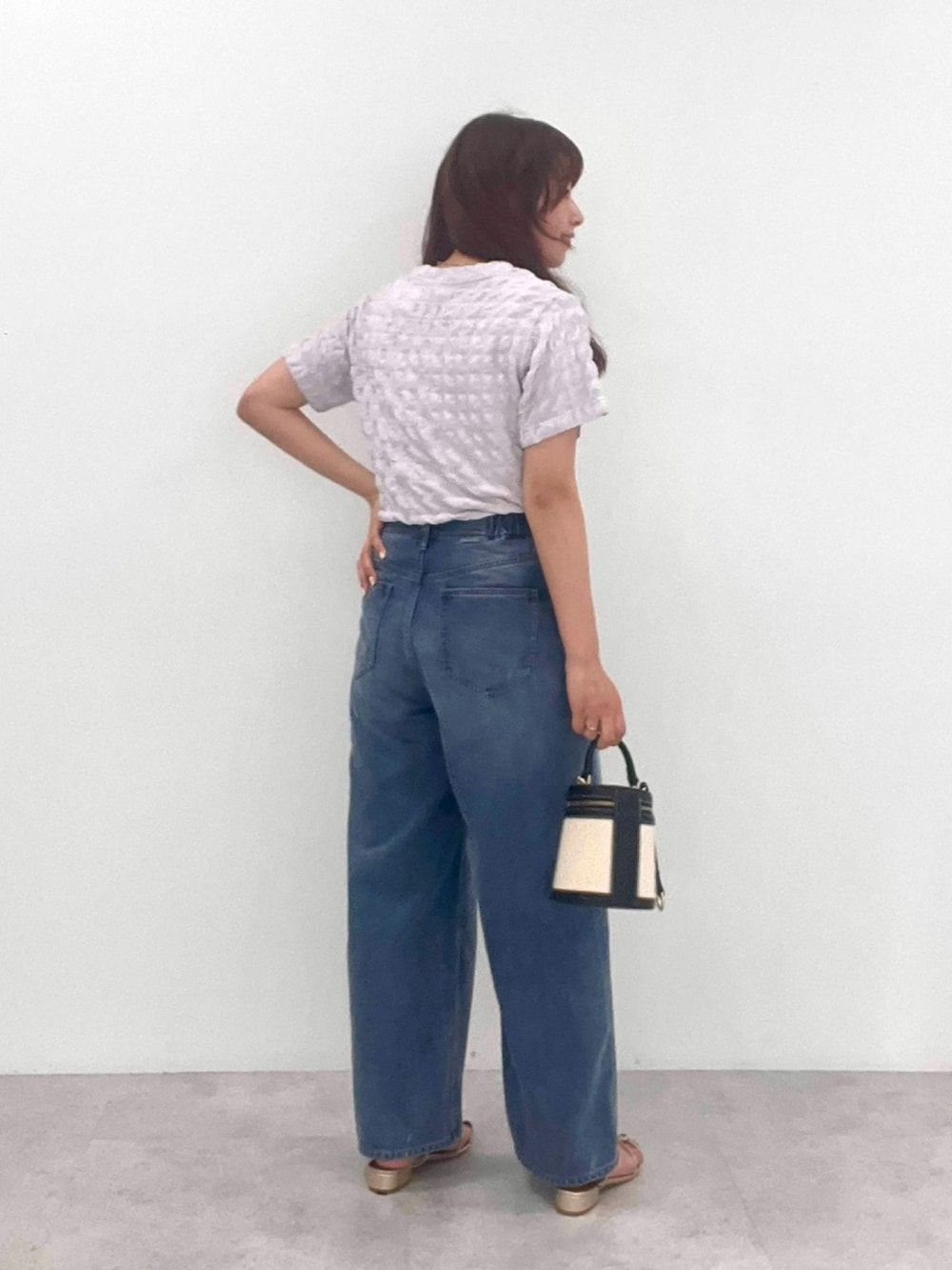 ブルー系のデニムパンツ、ホワイト系のTシャツ/カットソーを着用したレディースの夏コーディネートの2枚目の写真