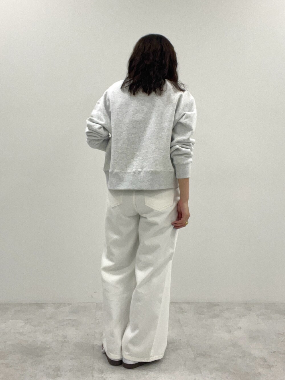 ホワイト系のスウェット、ホワイト系のデニムパンツを着用したレディースの冬コーディネートの4枚目の写真