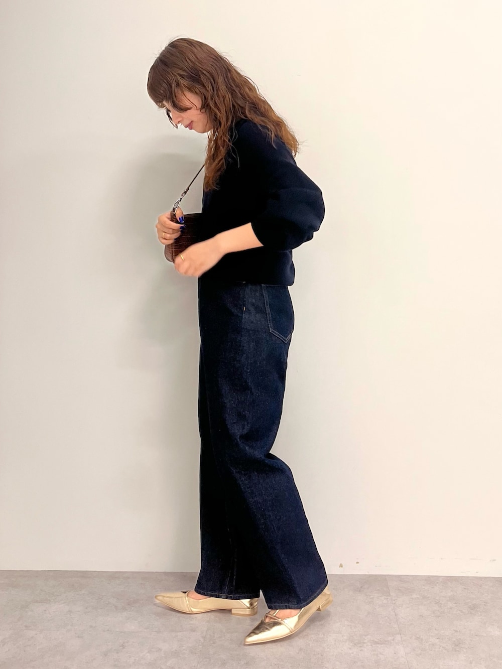 ブルー系のデニムパンツ、ブルー系のニット/セーターを着用したレディースの秋コーディネートの2枚目の写真