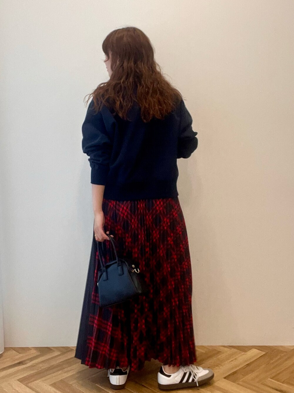 ブルー系のスウェット、レッド系のスカートを着用したレディースの秋コーディネートの3枚目の写真