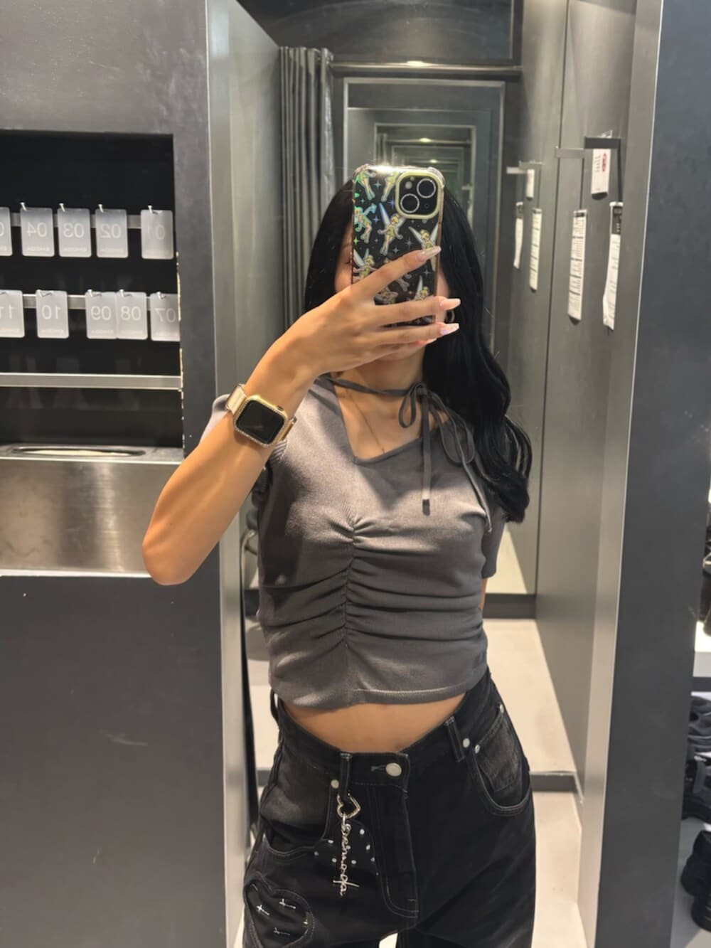 グレー系のニット/セーター、ブラック系のデニムパンツ、ブラック系のブーツを着用したレディースの秋コーディネートの5枚目の写真