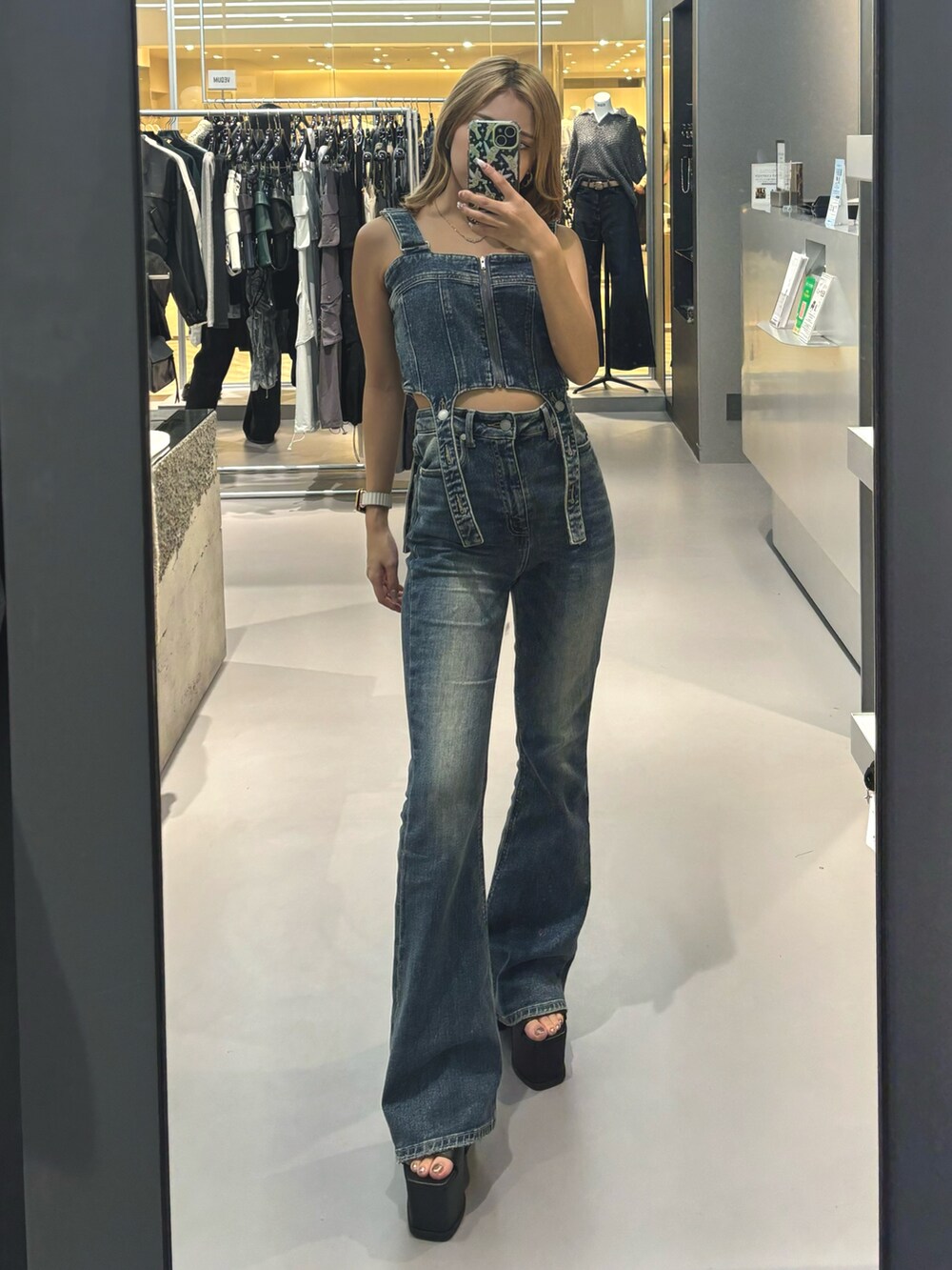 ホワイト系のシャツ/ブラウス、ブルー系のサロペット/オーバーオール、ブラック系のサンダルを着用したレディースの春コーディネートの3枚目の写真