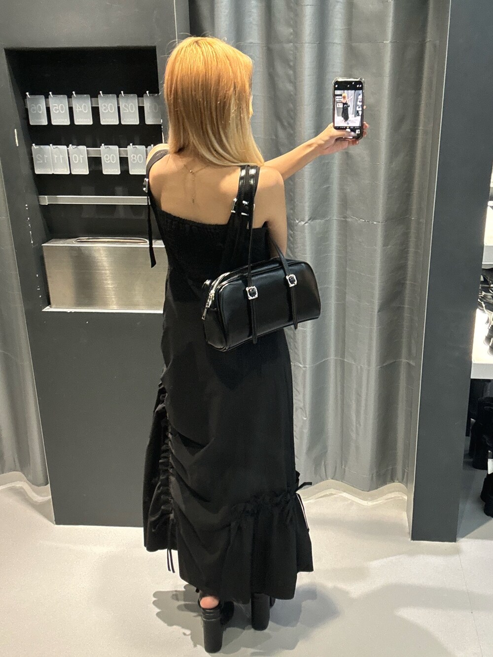 ブラック系のハンドバッグ、ブラック系のサンダル、ブラック系のワンピースを着用したレディースの春コーディネートの3枚目の写真