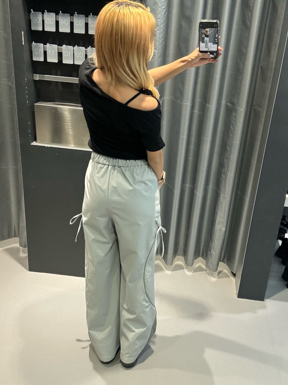 ブラック系のTシャツ/カットソー、グレー系のその他パンツ、ブラック系のサンダルを着用したレディースの春コーディネートの3枚目の写真