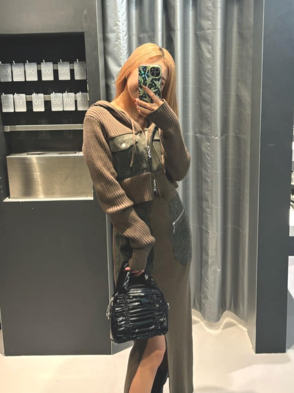 ブラック系のブーツ、グリーン系のニット/セーター、グリーン系のワンピースを着用したレディースの冬コーディネートの3枚目の写真