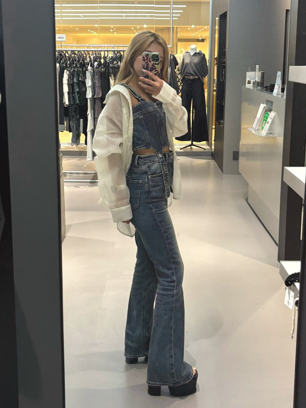 ホワイト系のシャツ/ブラウス、ブルー系のサロペット/オーバーオール、ブラック系のサンダルを着用したレディースの春コーディネートの2枚目の写真