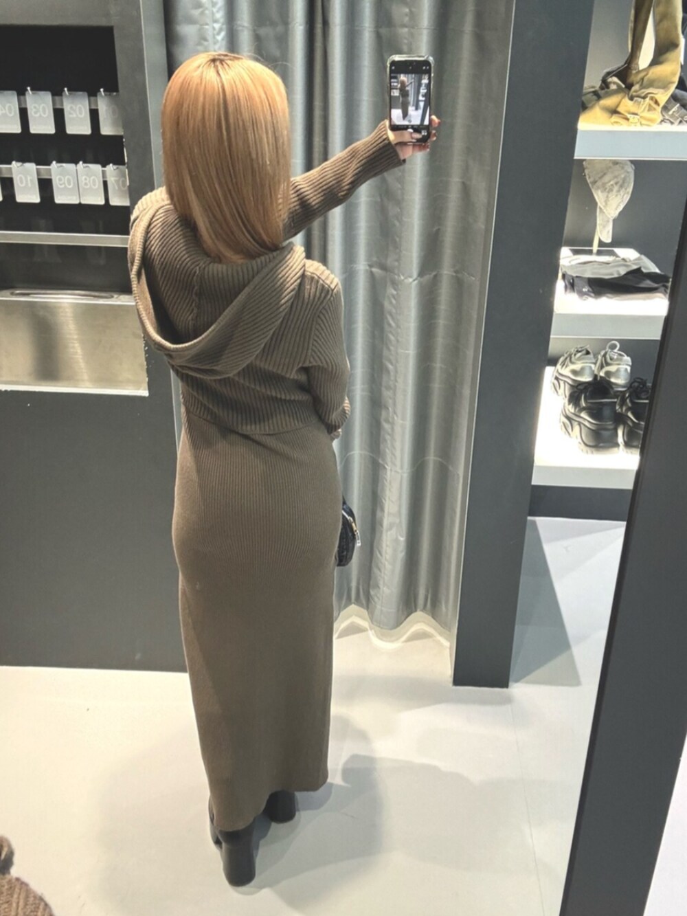 ブラック系のブーツ、グリーン系のニット/セーター、グリーン系のワンピースを着用したレディースの冬コーディネートの4枚目の写真