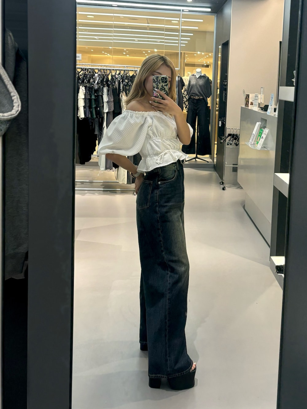 ホワイト系のTシャツ/カットソー、ブルー系のデニムパンツ、ブラック系のサンダルを着用したレディースの春コーディネートの2枚目の写真