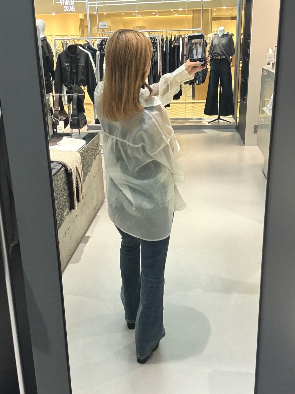 ホワイト系のシャツ/ブラウス、ブルー系のサロペット/オーバーオール、ブラック系のサンダルを着用したレディースの春コーディネートの4枚目の写真