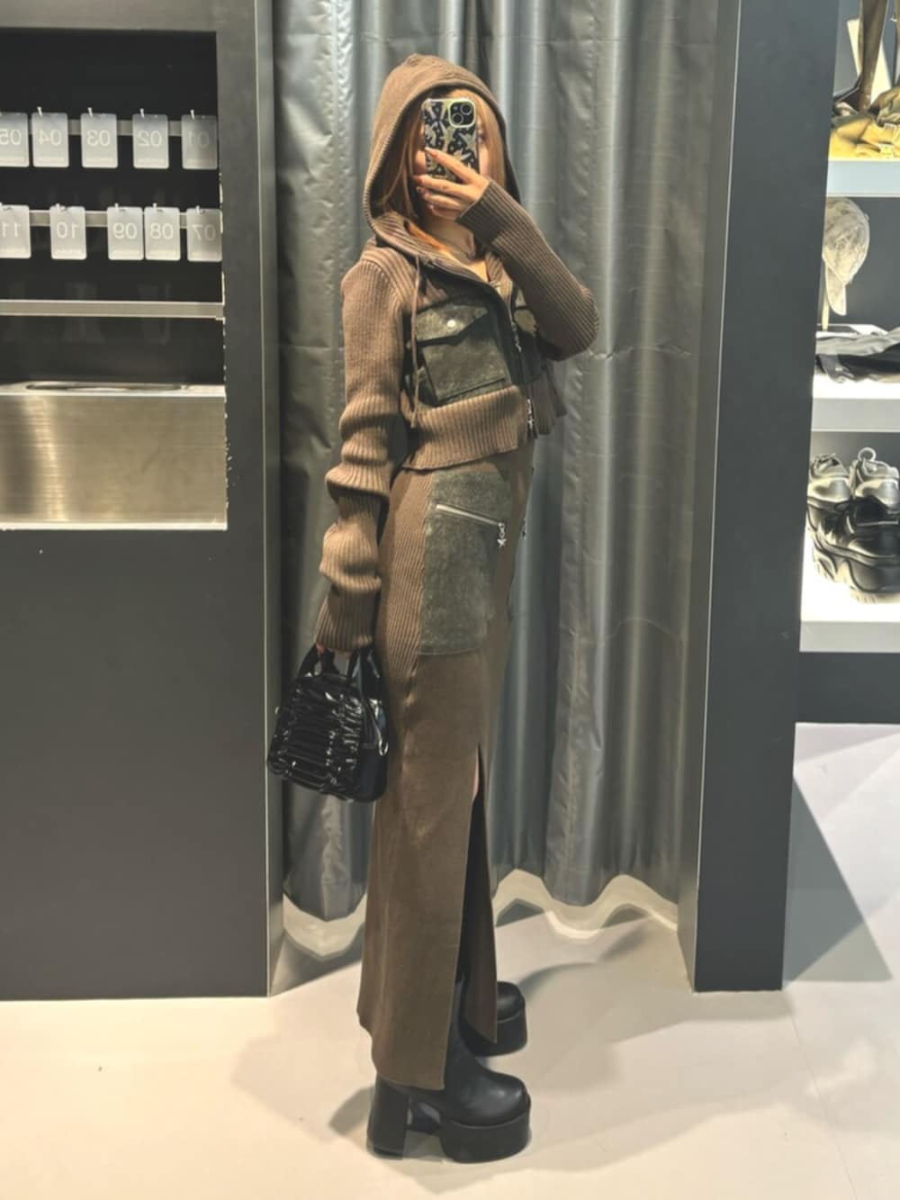 ブラック系のブーツ、グリーン系のニット/セーター、グリーン系のワンピースを着用したレディースの冬コーディネートの2枚目の写真