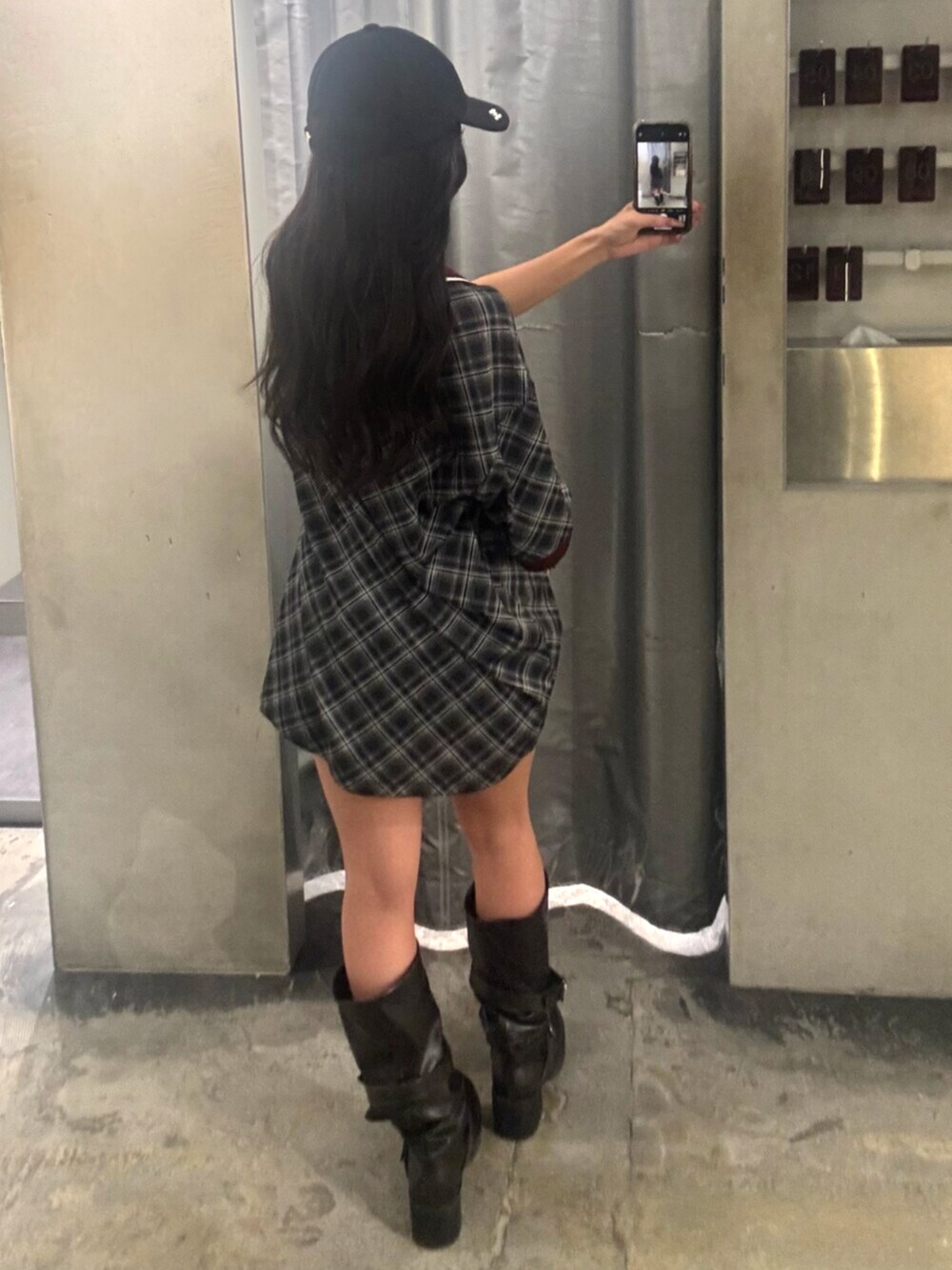 ブラック系のTシャツ/カットソー、ブラック系のブーツ、ブラック系のキャップを着用したレディースの冬コーディネートの3枚目の写真