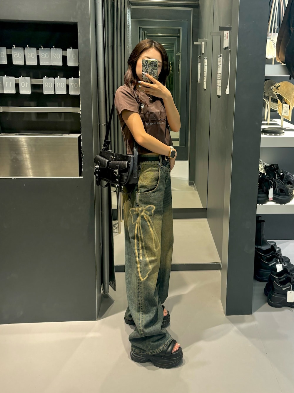 ブラウン系のTシャツ/カットソー、ブラック系のサンダル、ブルー系のデニムパンツを着用したレディースの夏コーディネートの2枚目の写真