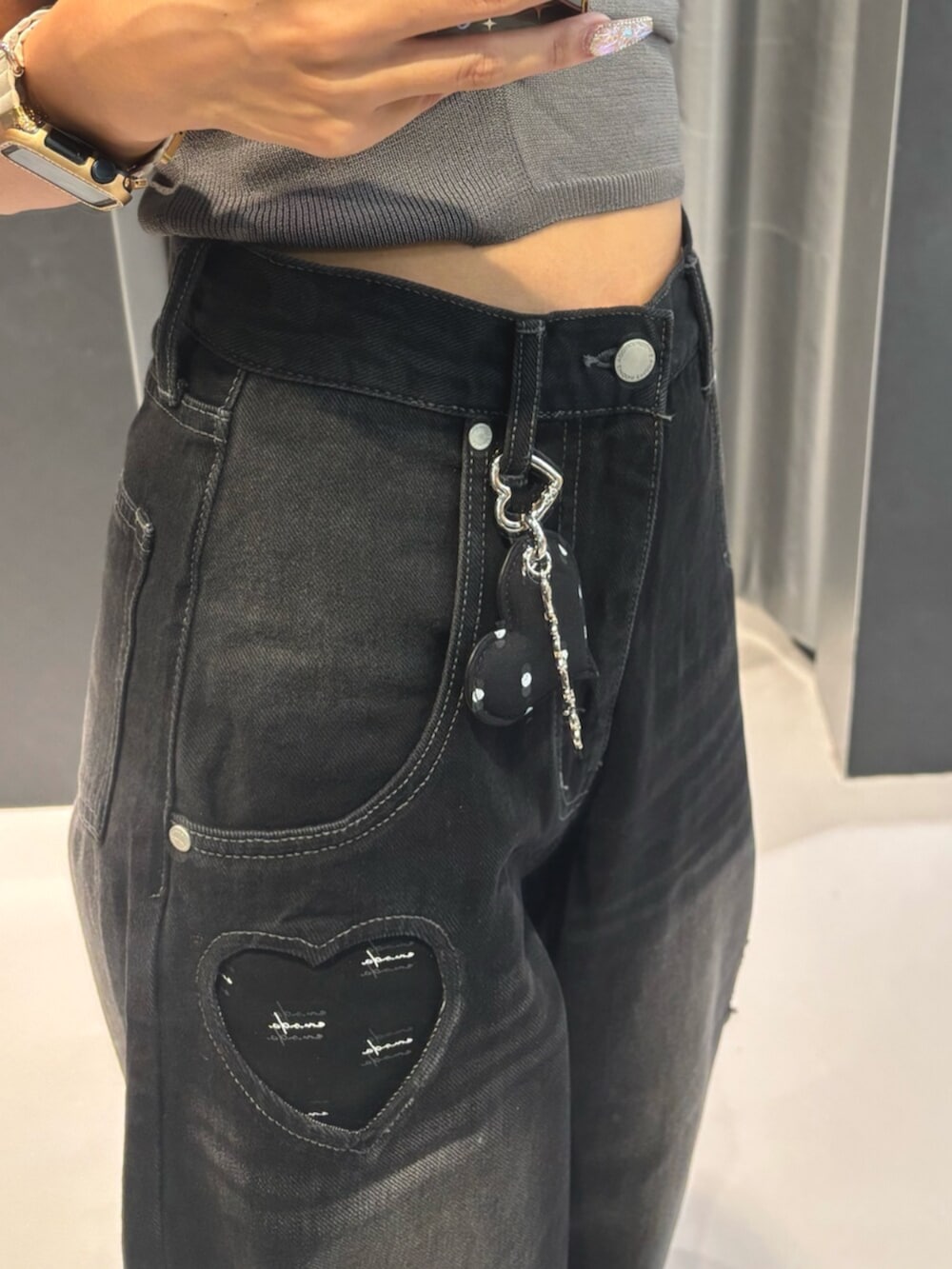 グレー系のニット/セーター、ブラック系のデニムパンツ、ブラック系のブーツを着用したレディースの秋コーディネートの4枚目の写真