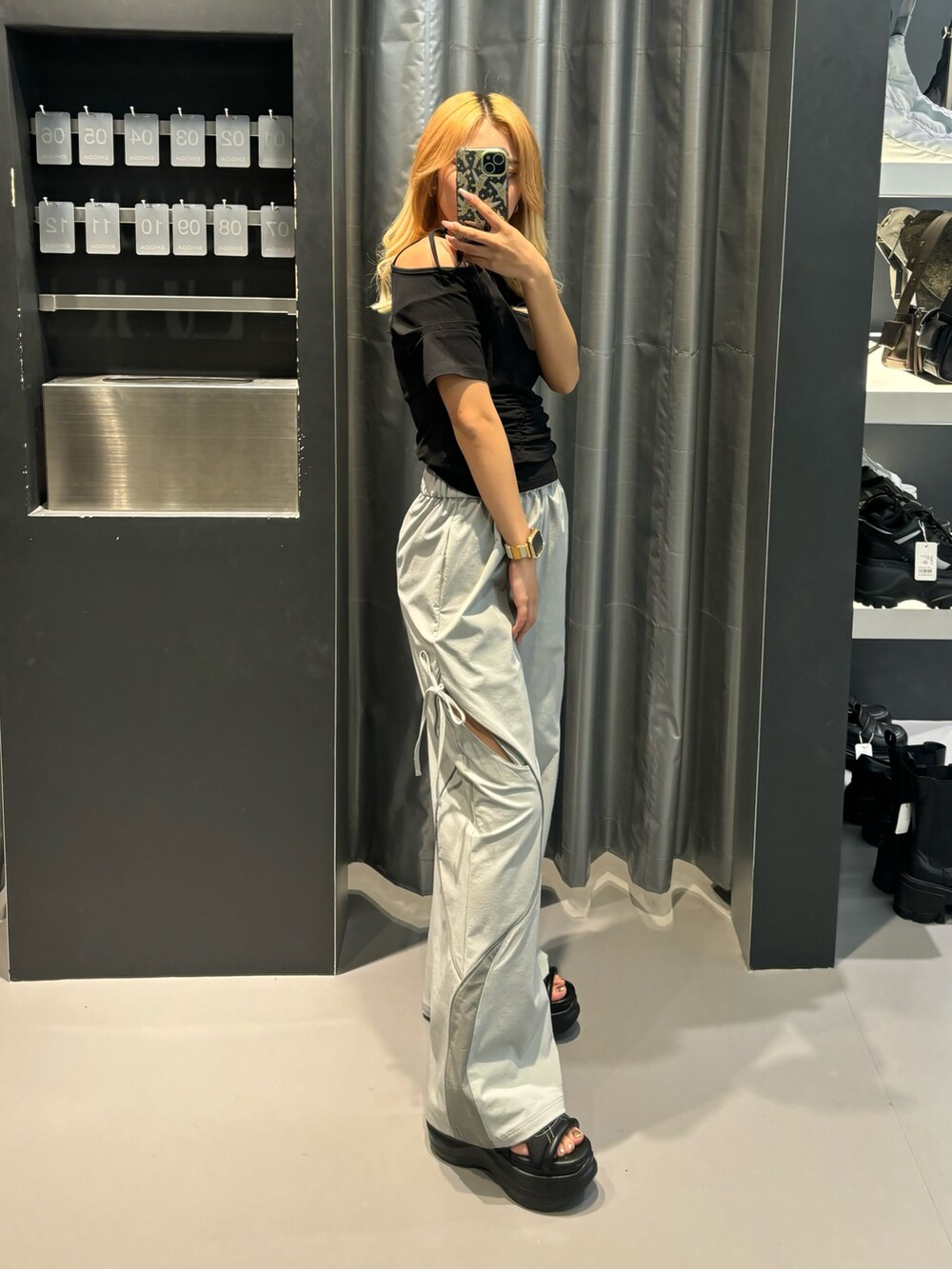 ブラック系のTシャツ/カットソー、グレー系のその他パンツ、ブラック系のサンダルを着用したレディースの春コーディネートの2枚目の写真