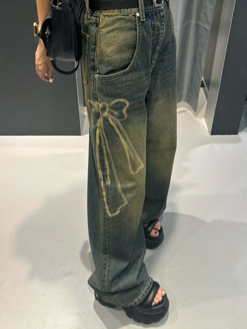 ブラウン系のTシャツ/カットソー、ブラック系のサンダル、ブルー系のデニムパンツを着用したレディースの夏コーディネートの4枚目の写真