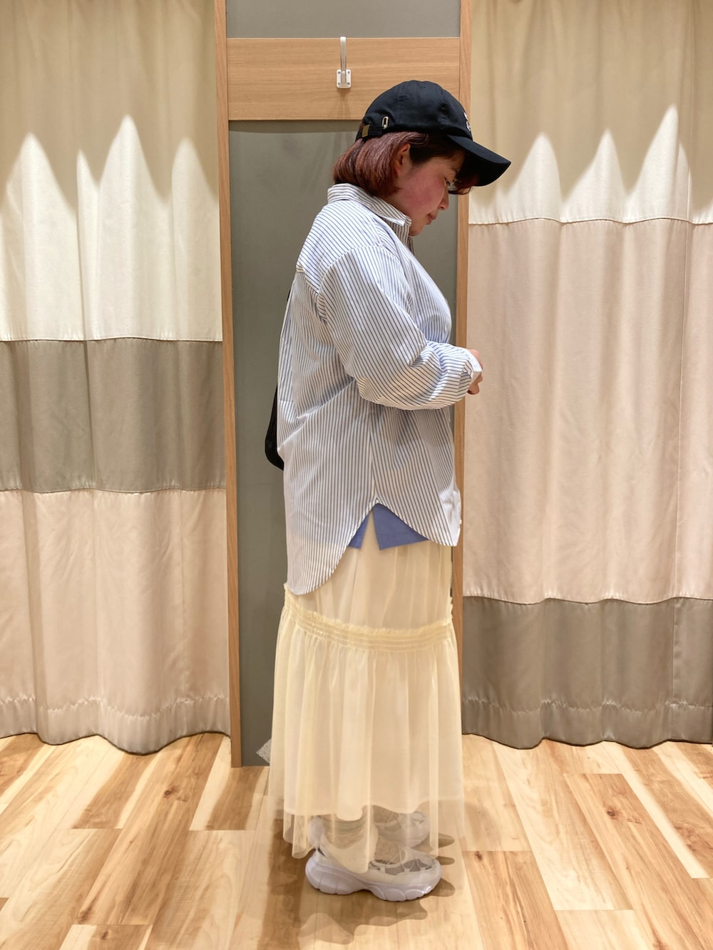 ホワイト系のドレスシューズ、ブラック系のハンドバッグ、ブルー系のTシャツ/カットソーを着用したレディースの春コーディネートの2枚目の写真