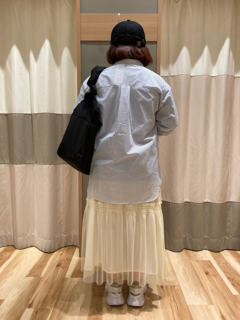 ホワイト系のドレスシューズ、ブラック系のハンドバッグ、ブルー系のTシャツ/カットソーを着用したレディースの春コーディネートの3枚目の写真