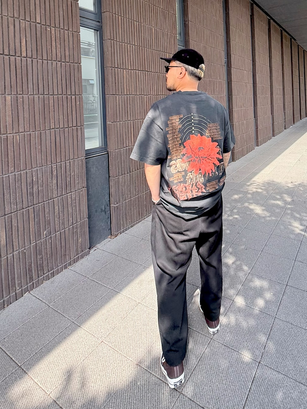 ブラック系のその他パンツ、ブラウン系のスニーカー、ブラック系のTシャツ/カットソーを着用したメンズの春コーディネートの2枚目の写真
