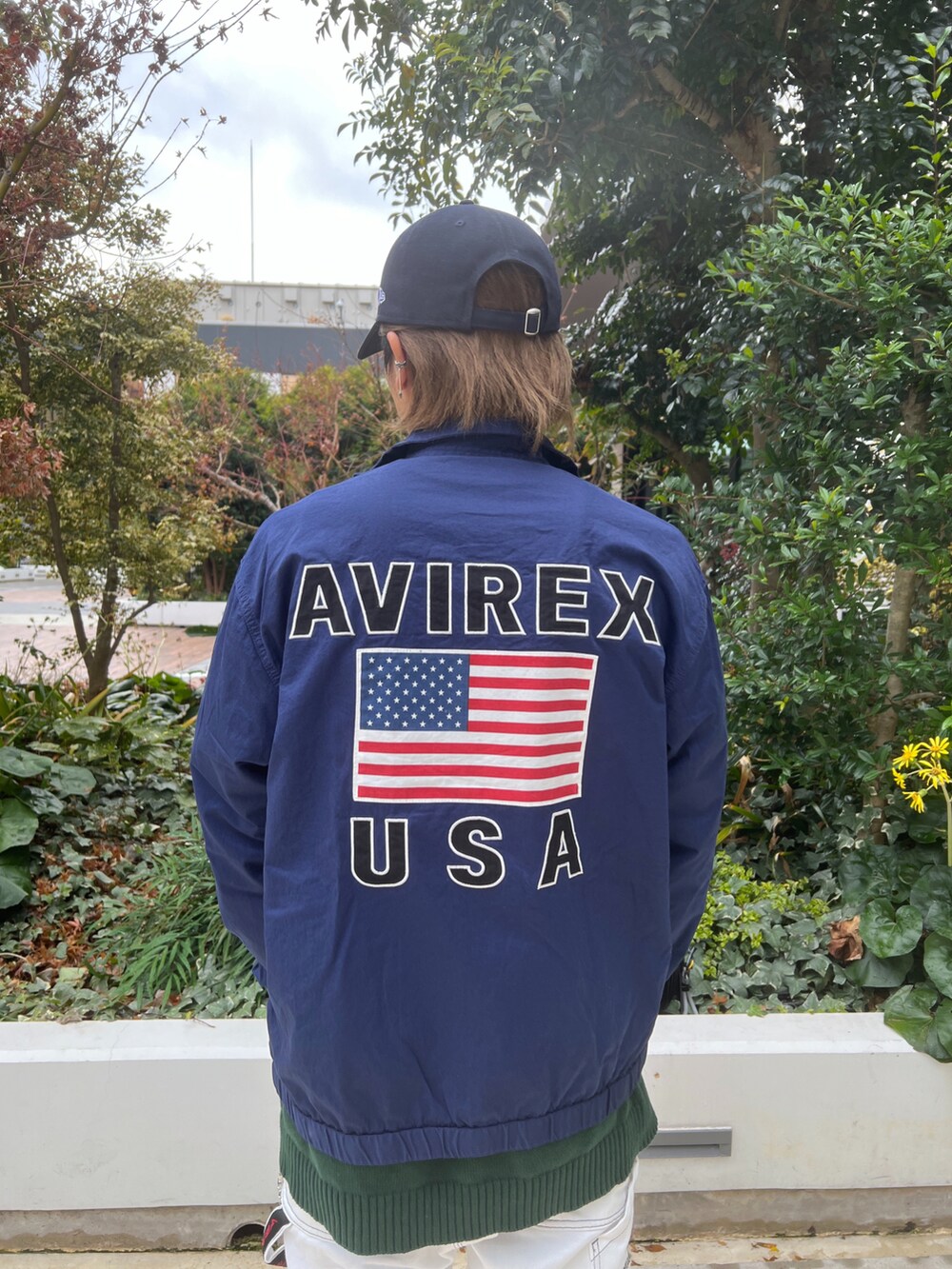 ブルー系のその他アウター、グリーン系のニット/セーター、ホワイト系のデニムパンツを着用したメンズの冬コーディネートの3枚目の写真