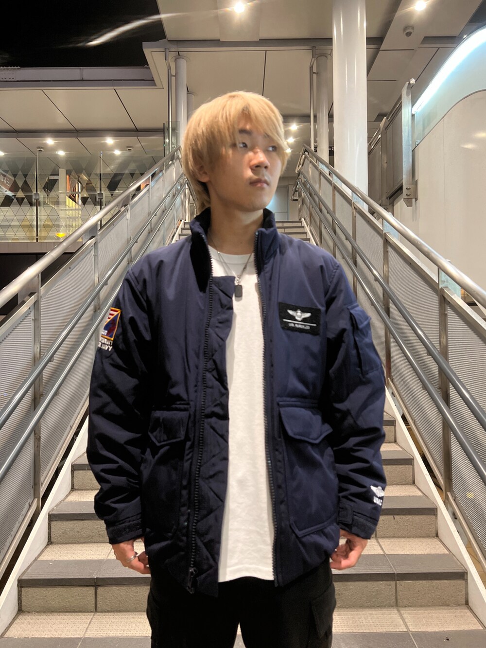 ブルー系のブルゾン、ブラック系のカーゴパンツを着用したメンズの秋コーディネートの2枚目の写真