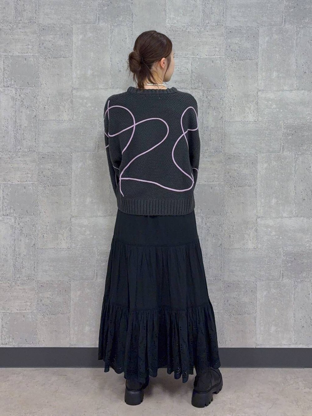 ブラック系のブーツ、グレー系のニット/セーター、ブラック系のスカートを着用したレディースの秋コーディネートの5枚目の写真