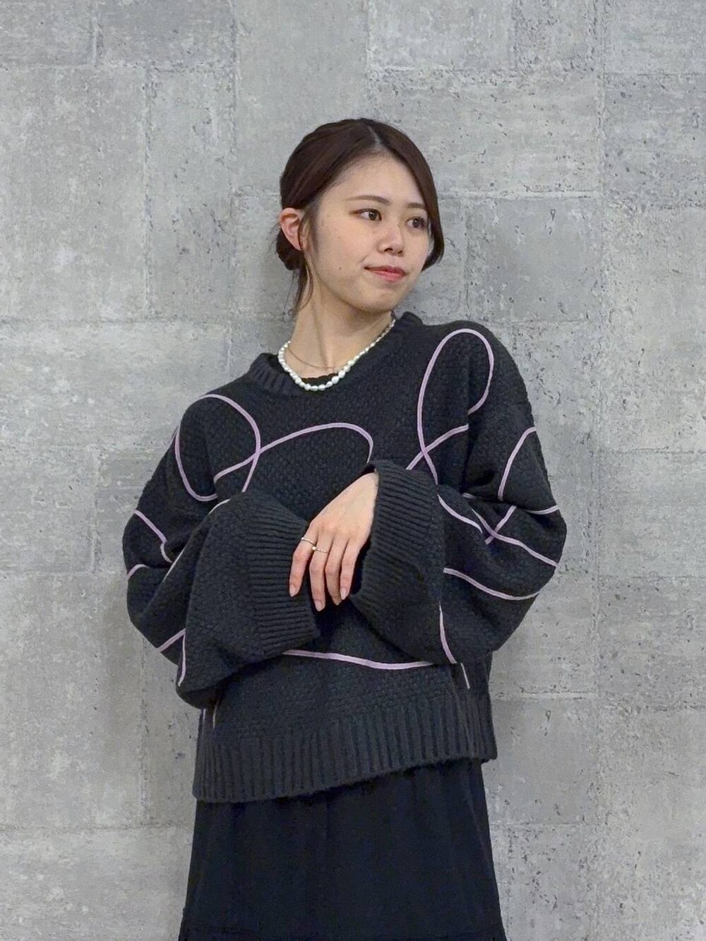 ブラック系のブーツ、グレー系のニット/セーター、ブラック系のスカートを着用したレディースの秋コーディネートの2枚目の写真