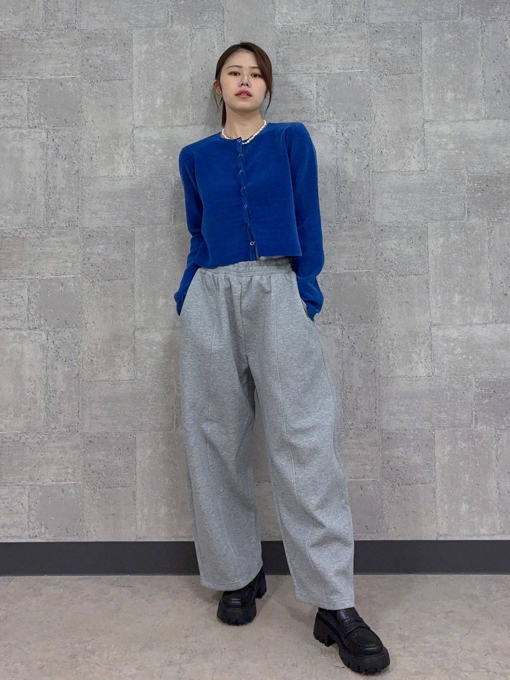 ブラック系のローファー、ブルー系のカーディガン/ボレロ、グレー系のスウェットパンツを着用したレディースの秋コーディネートの2枚目の写真