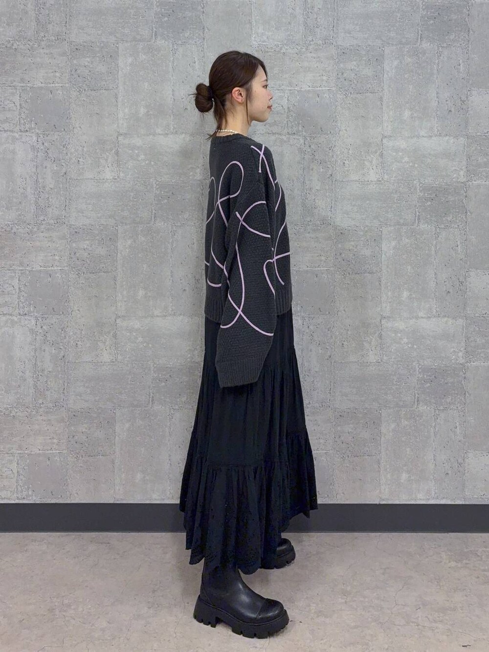 ブラック系のブーツ、グレー系のニット/セーター、ブラック系のスカートを着用したレディースの秋コーディネートの4枚目の写真