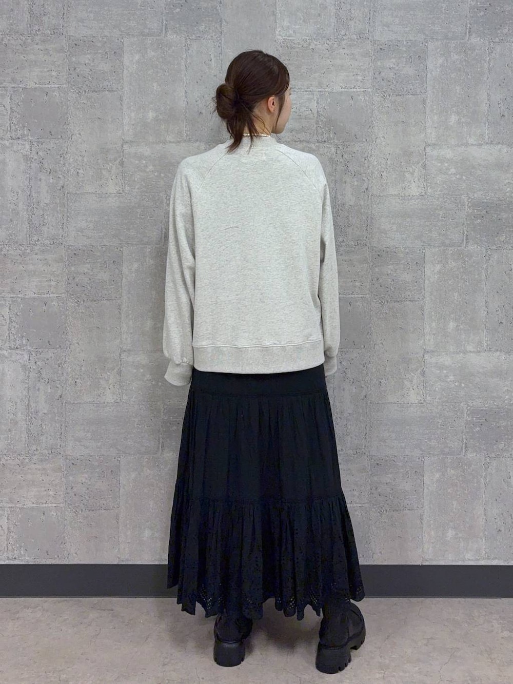 ブラック系のブーツ、ホワイト系のスウェット、ブラック系のスカートを着用したレディースの秋コーディネートの5枚目の写真