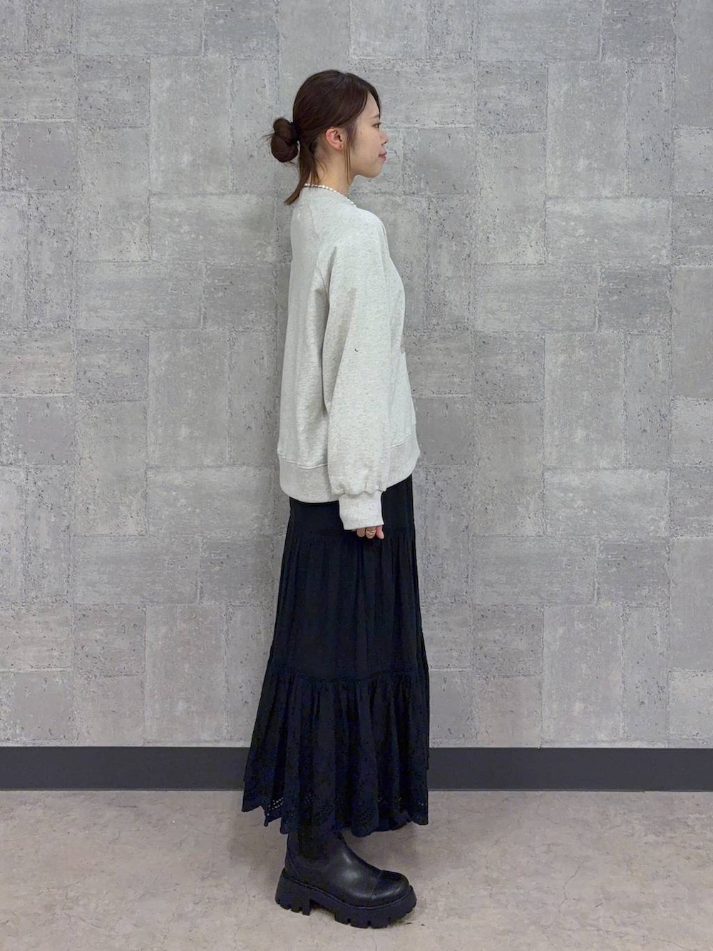 ブラック系のブーツ、ホワイト系のスウェット、ブラック系のスカートを着用したレディースの秋コーディネートの4枚目の写真