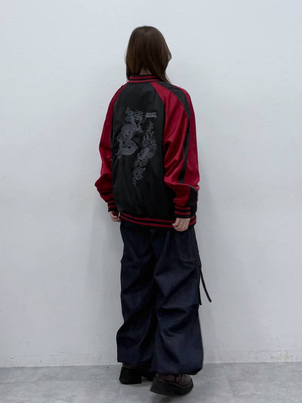 ブラック系のスカジャンを着用したレディースの春コーディネートの3枚目の写真