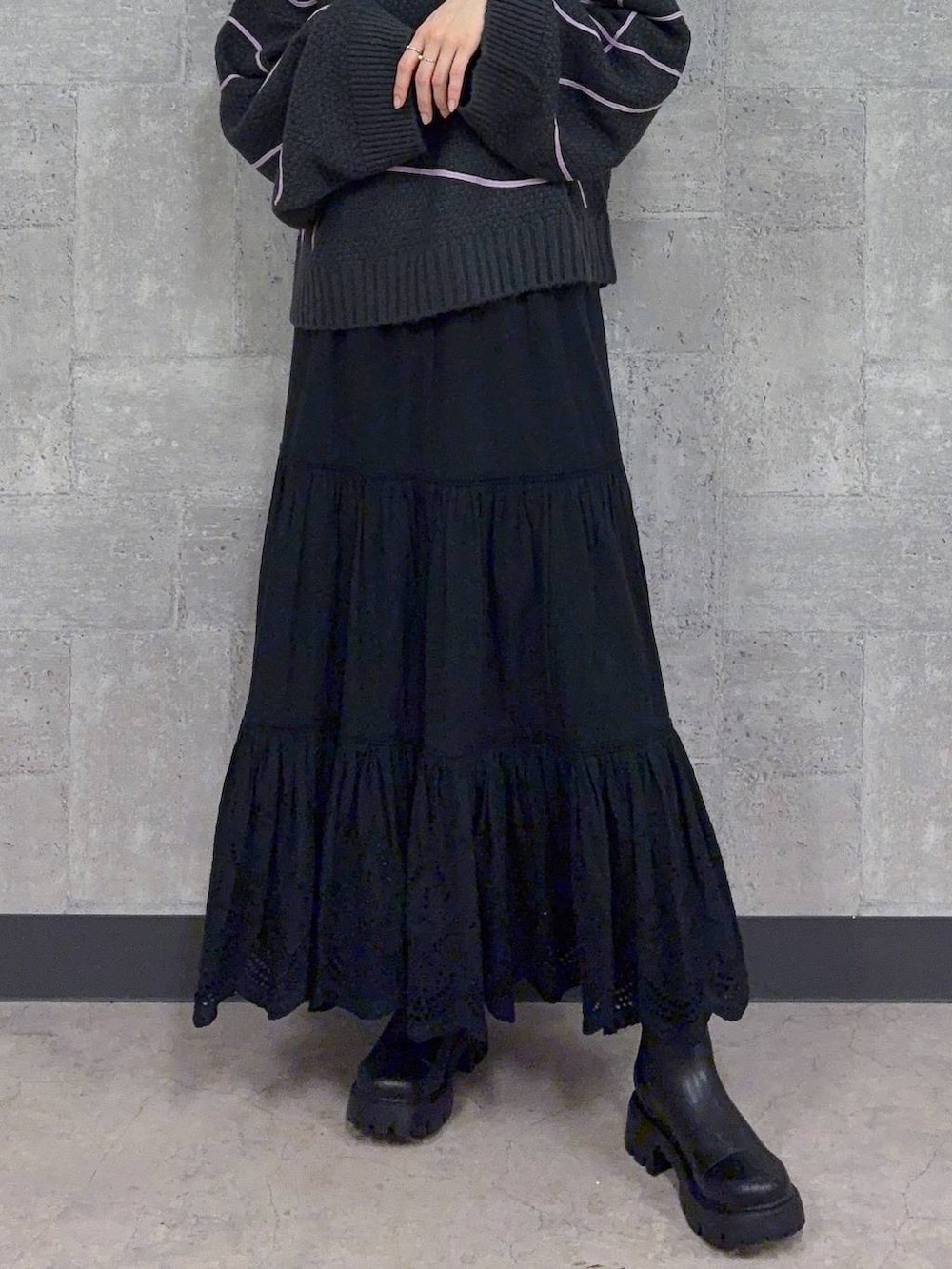 ブラック系のブーツ、グレー系のニット/セーター、ブラック系のスカートを着用したレディースの秋コーディネートの3枚目の写真