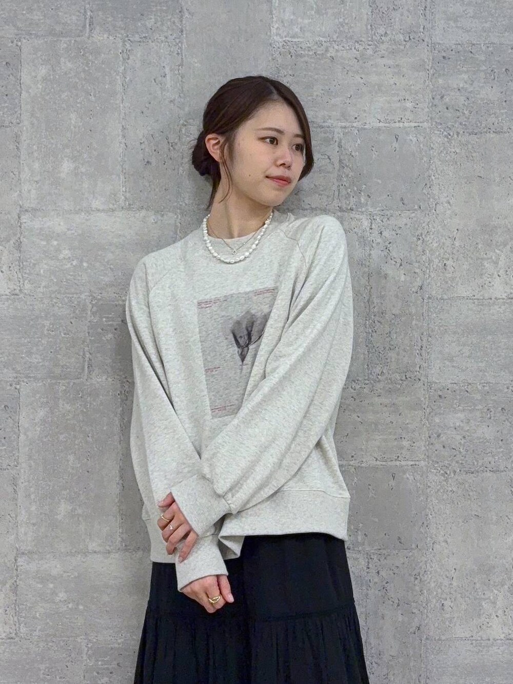 ブラック系のブーツ、ホワイト系のスウェット、ブラック系のスカートを着用したレディースの秋コーディネートの2枚目の写真