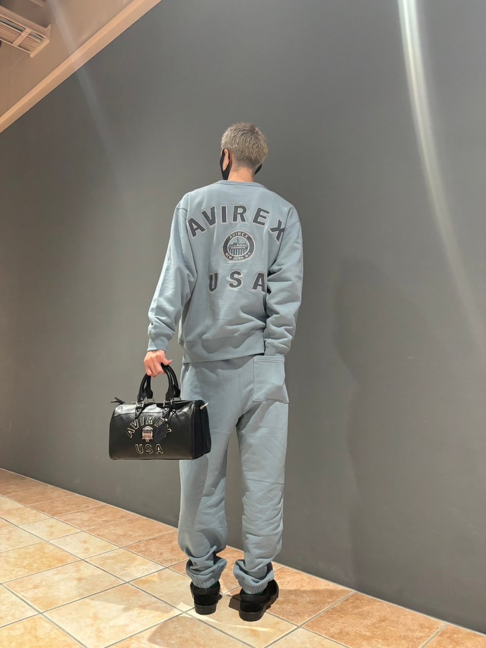 ブルー系のスウェット、ブルー系のスウェットパンツ、ブラック系のボストンバッグを着用したメンズの秋コーディネートの2枚目の写真