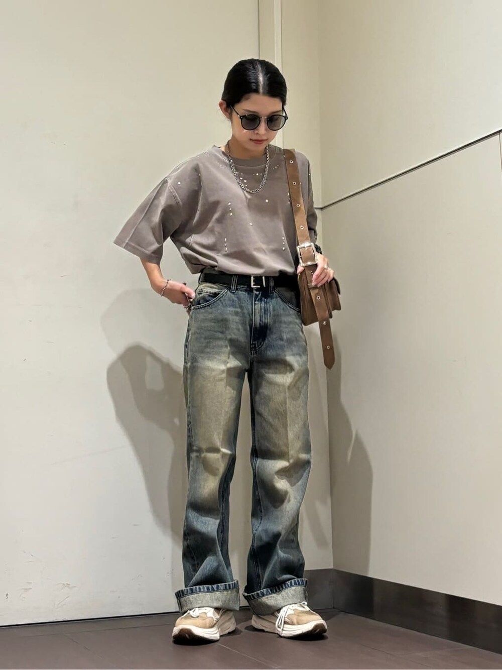ブラウン系のショルダーバッグ、ブルー系のデニムパンツ、ブラウン系のTシャツ/カットソーを着用したレディースの夏コーディネートの2枚目の写真