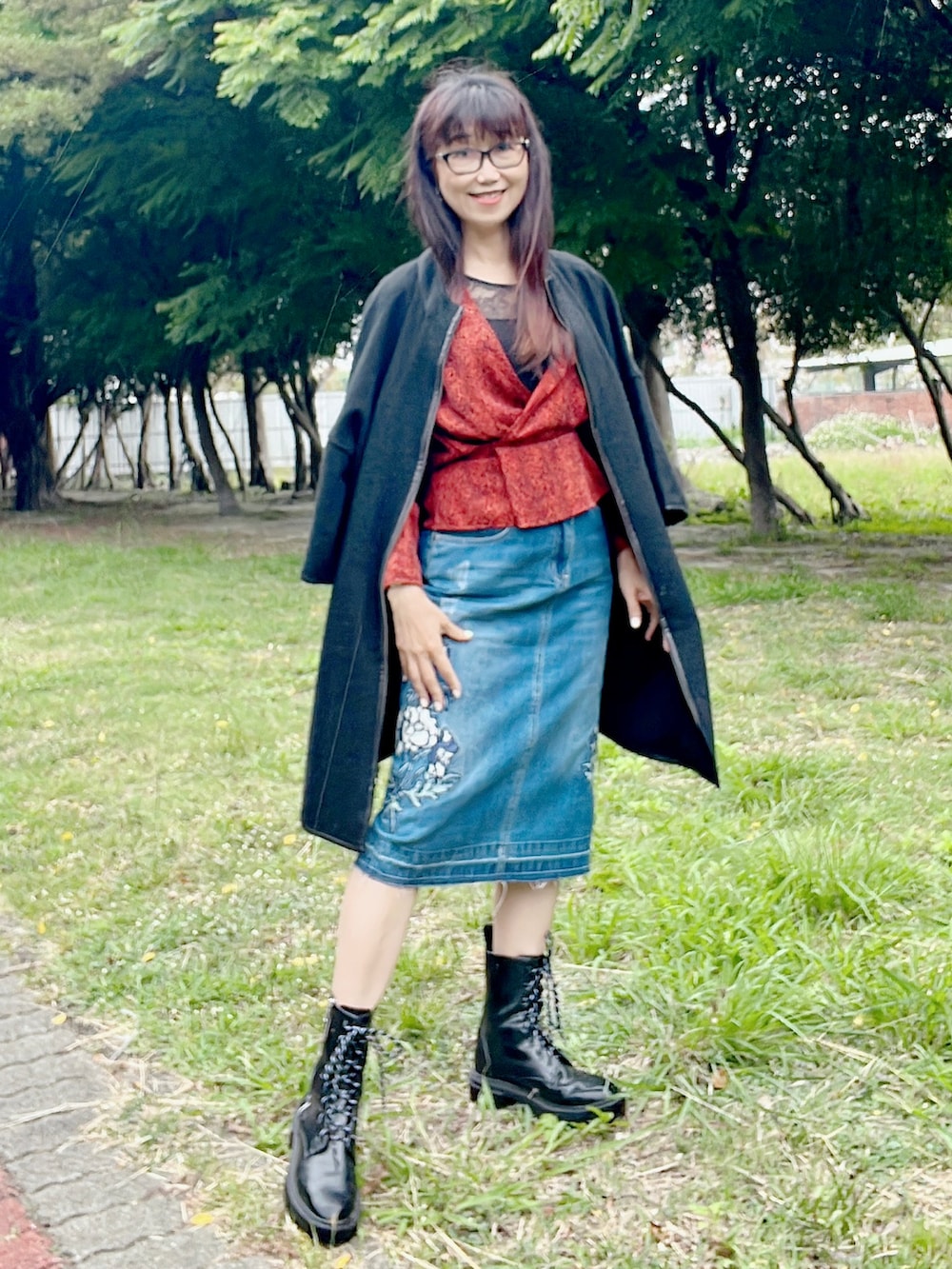 オレンジ系のその他トップス、ブルー系のデニムスカート、ブラック系のブーツを着用したレディースの春コーディネートの3枚目の写真