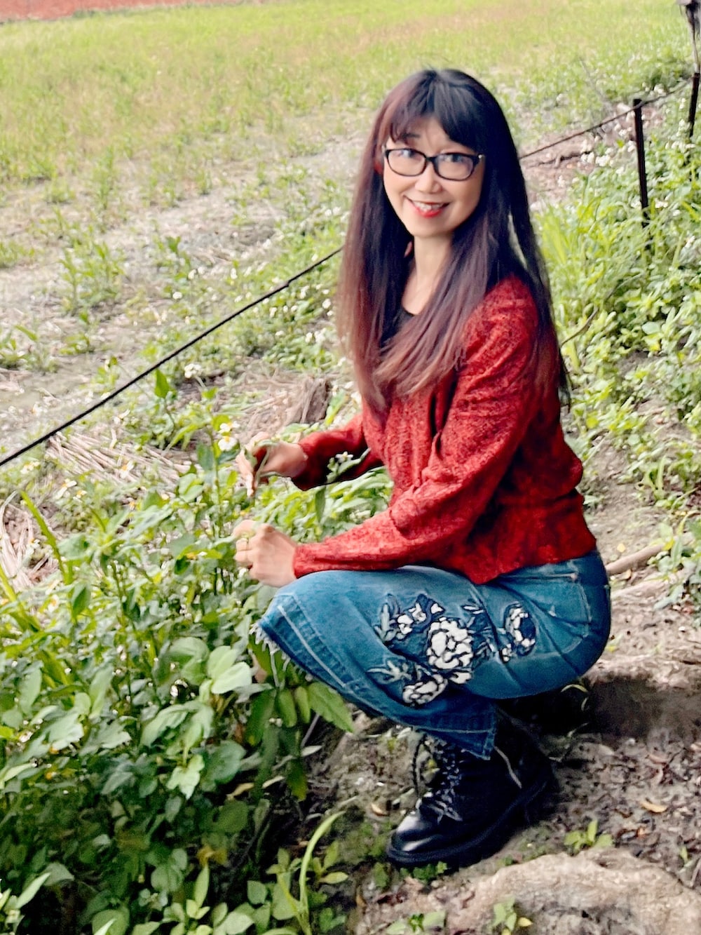 オレンジ系のその他トップス、ブルー系のデニムスカート、ブラック系のブーツを着用したレディースの春コーディネートの2枚目の写真