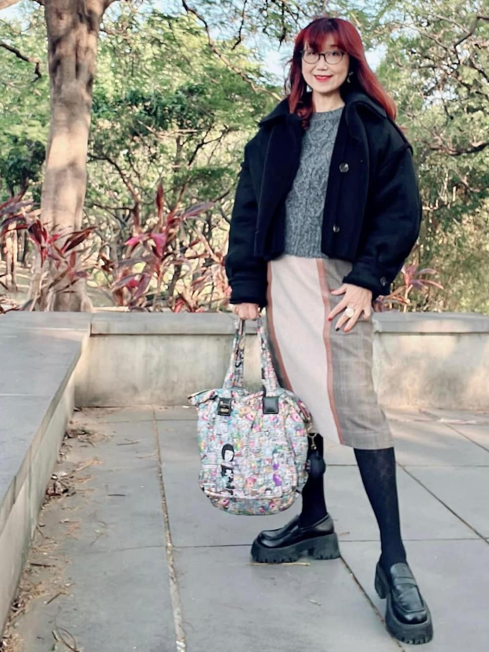 ブラック系のブルゾン、グレー系のその他トップス、ベージュ系のスカートを着用したレディースの冬コーディネートの4枚目の写真