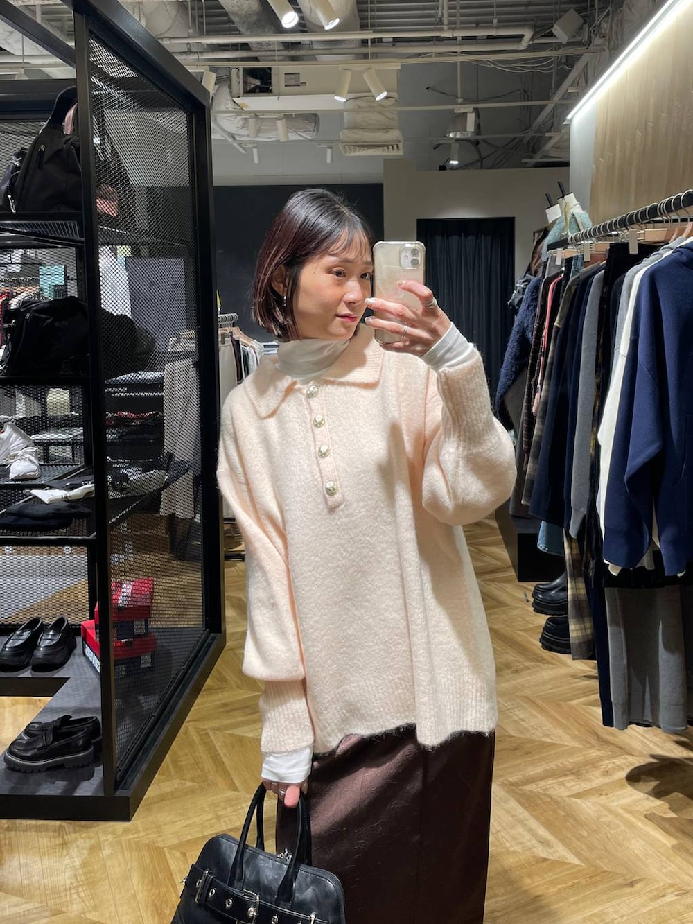 ブラック系のローファー、ブラック系のボストンバッグ、ホワイト系のTシャツ/カットソーを着用したレディースの冬コーディネートの2枚目の写真