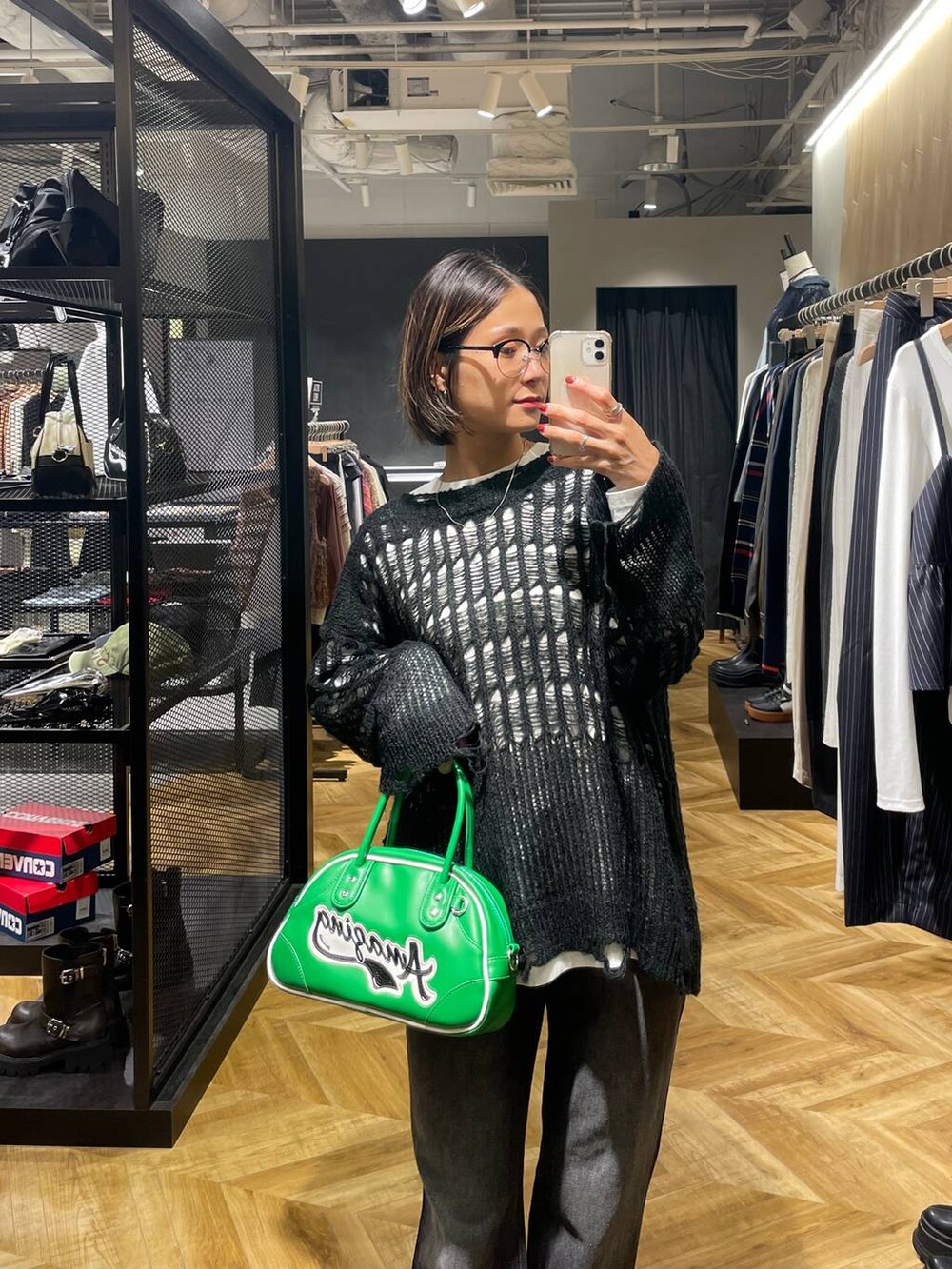 ブラック系のデニムパンツ、グリーン系のショルダーバッグ、ホワイト系のTシャツ/カットソーを着用したレディースの秋コーディネートの2枚目の写真