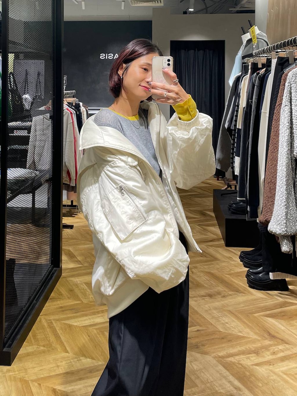 ホワイト系のブルゾン、ブラック系のローファー、ブラック系のスラックスを着用したレディースの秋コーディネートの5枚目の写真