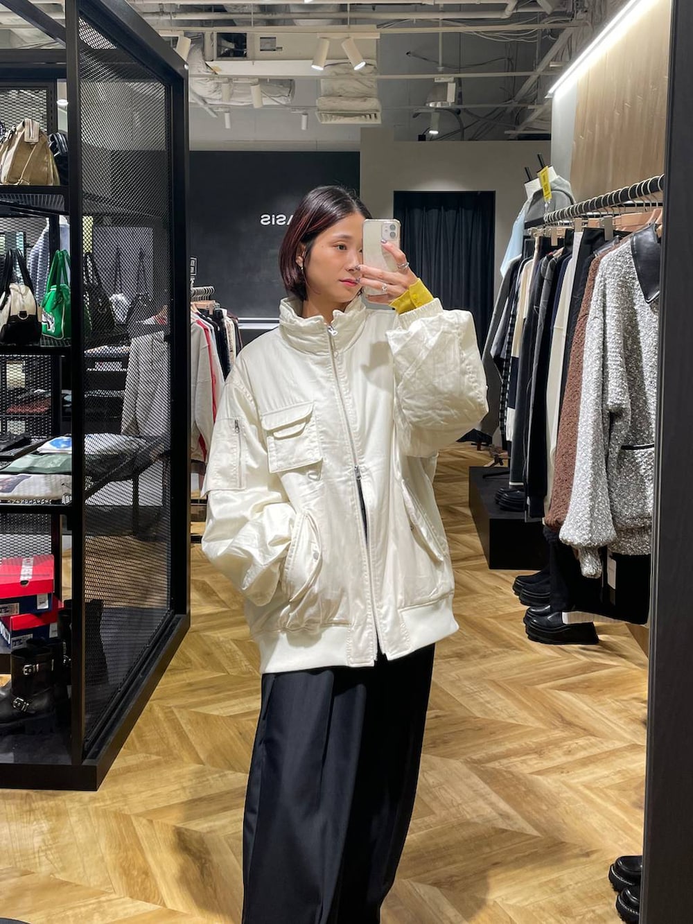 ホワイト系のブルゾン、ブラック系のローファー、ブラック系のスラックスを着用したレディースの秋コーディネートの4枚目の写真