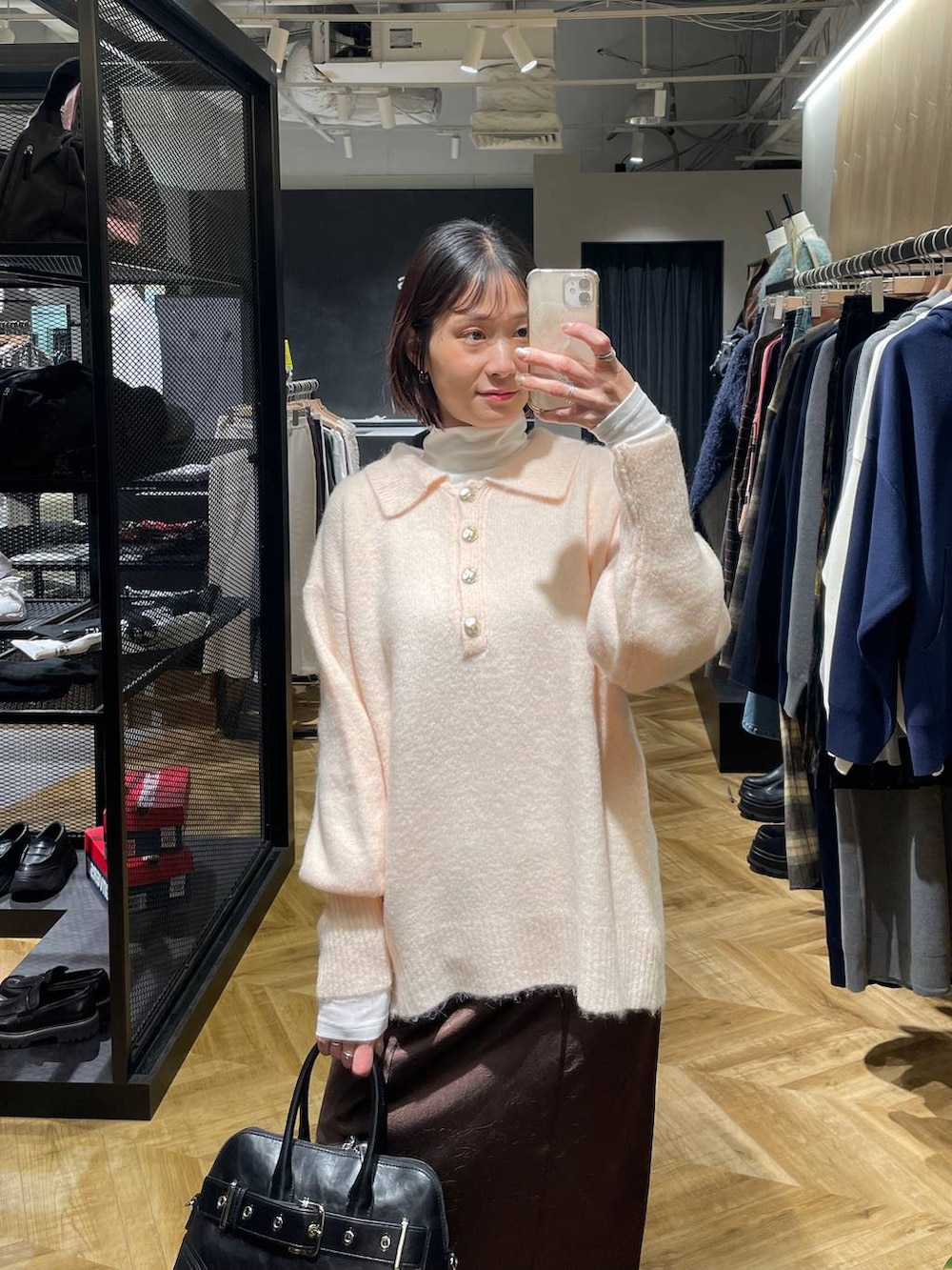 ブラック系のローファー、ブラック系のボストンバッグ、ホワイト系のTシャツ/カットソーを着用したレディースの冬コーディネートの4枚目の写真