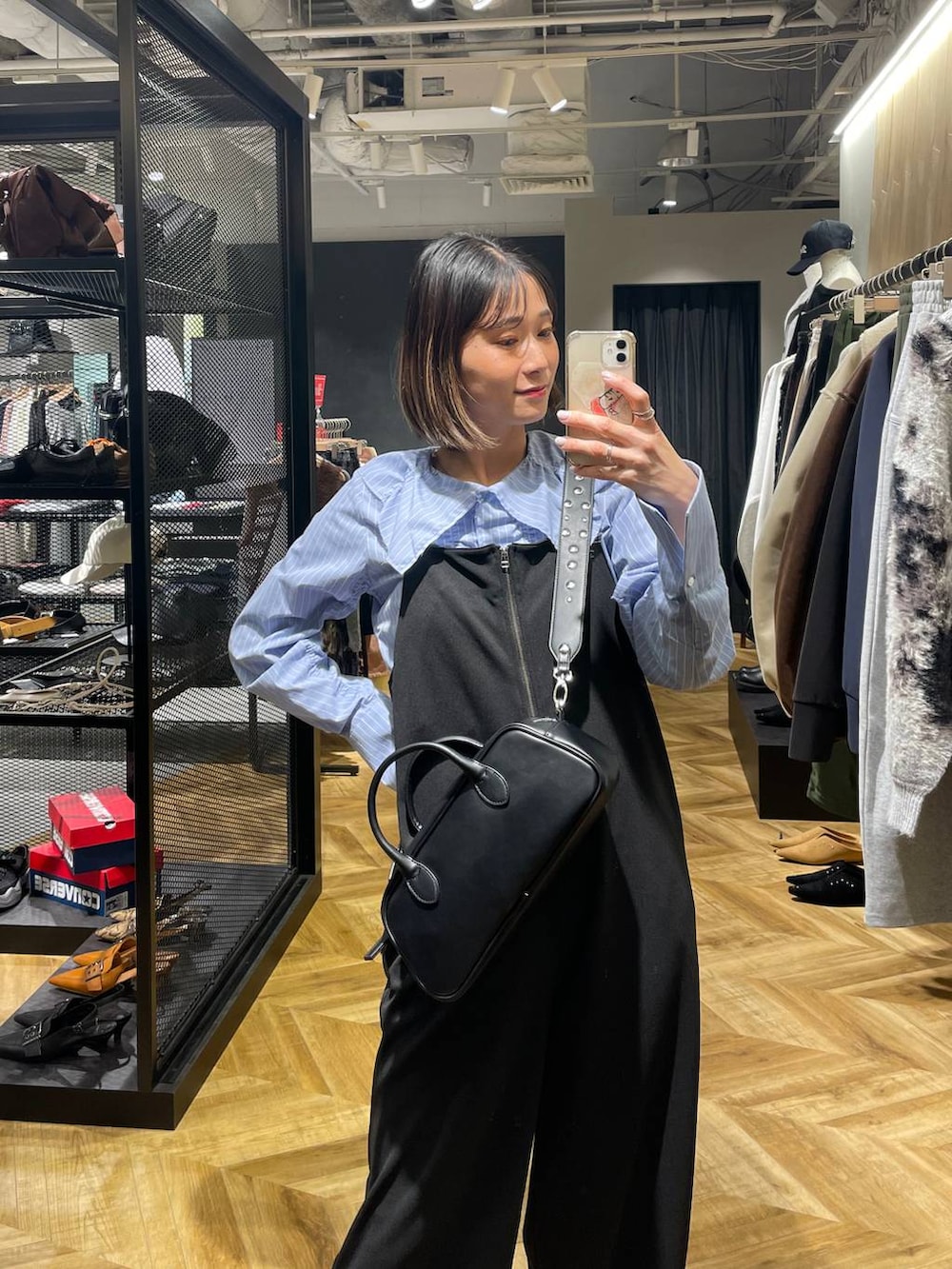 ブラック系のサロペット/オーバーオール、ブラック系のボストンバッグ、ブラック系のローファーを着用したレディースの冬コーディネートの2枚目の写真