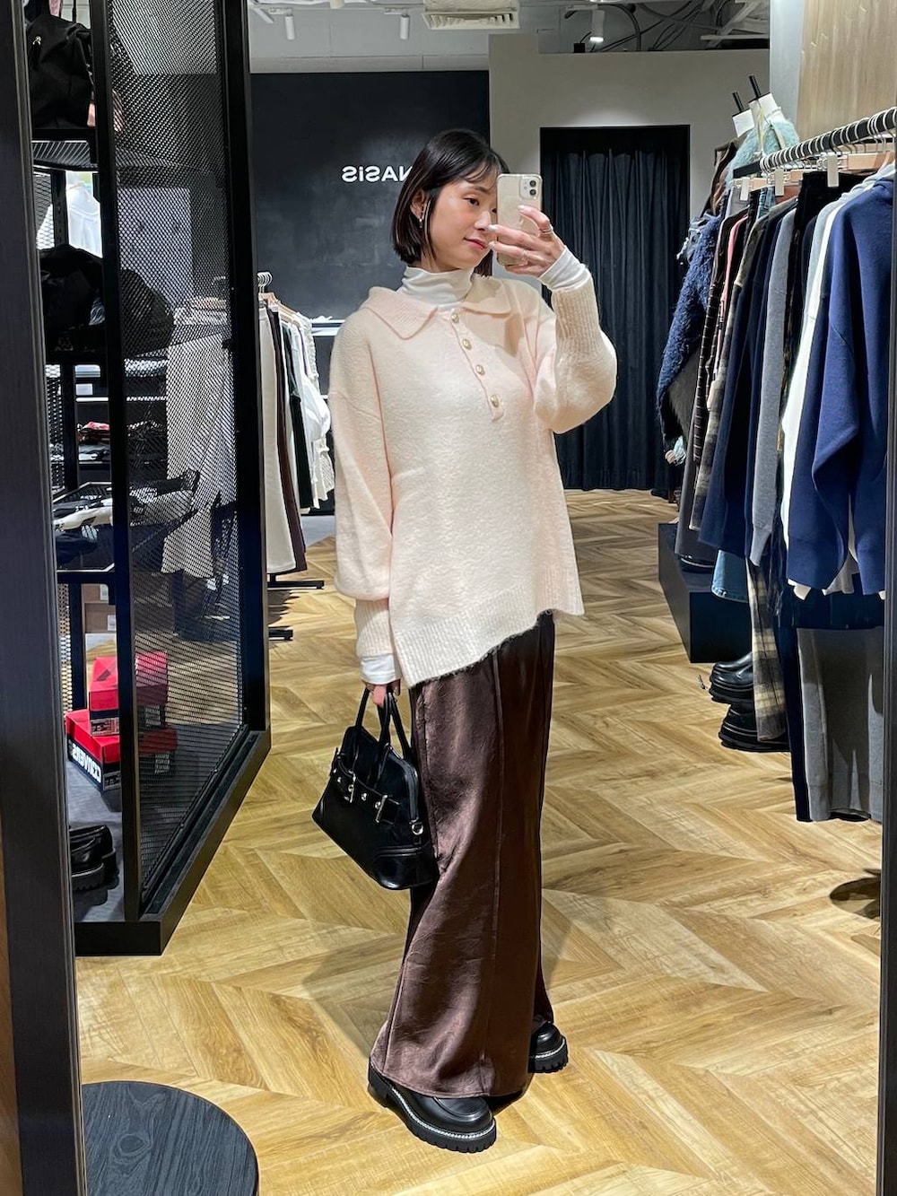 ブラック系のローファー、ブラック系のボストンバッグ、ホワイト系のTシャツ/カットソーを着用したレディースの冬コーディネートの3枚目の写真